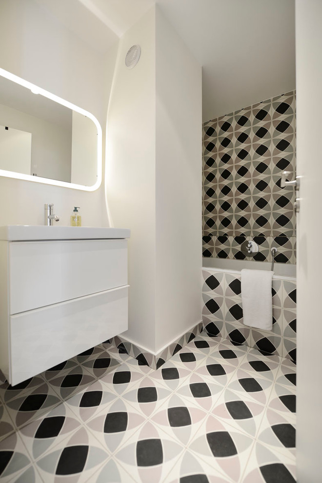 Стильный дизайн: главная ванная комната среднего размера в современном стиле с плоскими фасадами, белыми фасадами, ванной в нише, душем над ванной, разноцветной плиткой, белыми стенами, накладной раковиной и зеркалом с подсветкой - последний тренд