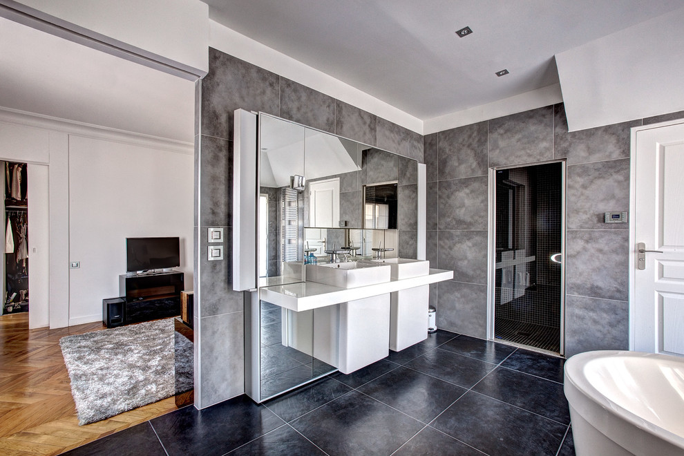 Foto di una grande stanza da bagno padronale design con lavabo sospeso, vasca freestanding, pareti grigie, doccia alcova e piastrelle grigie