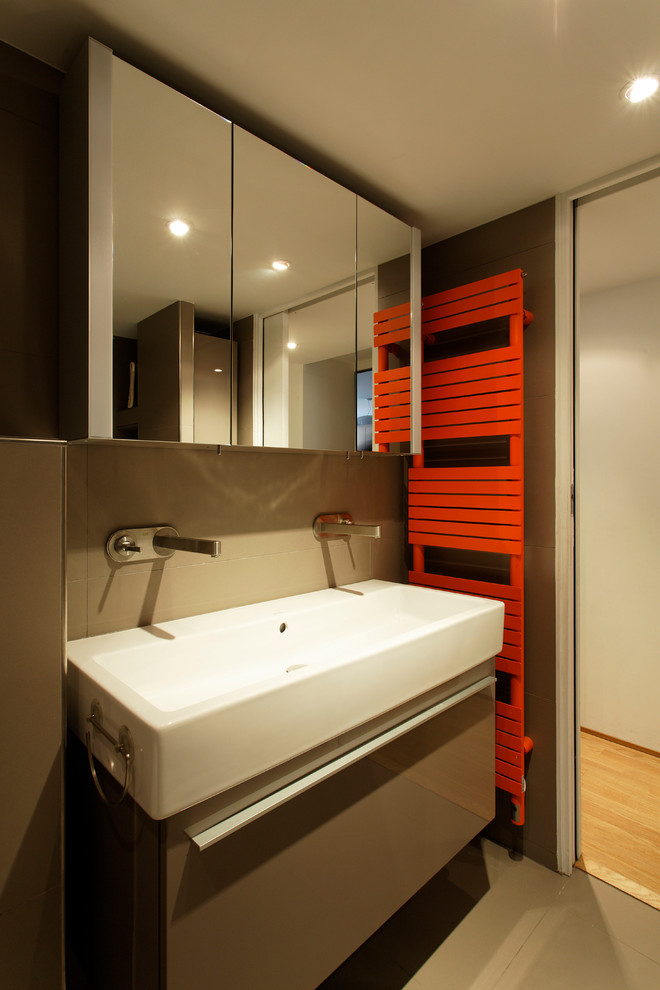 Foto de cuarto de baño contemporáneo con puertas de armario grises, paredes marrones, suelo de baldosas de cerámica, aseo y ducha y lavabo de seno grande