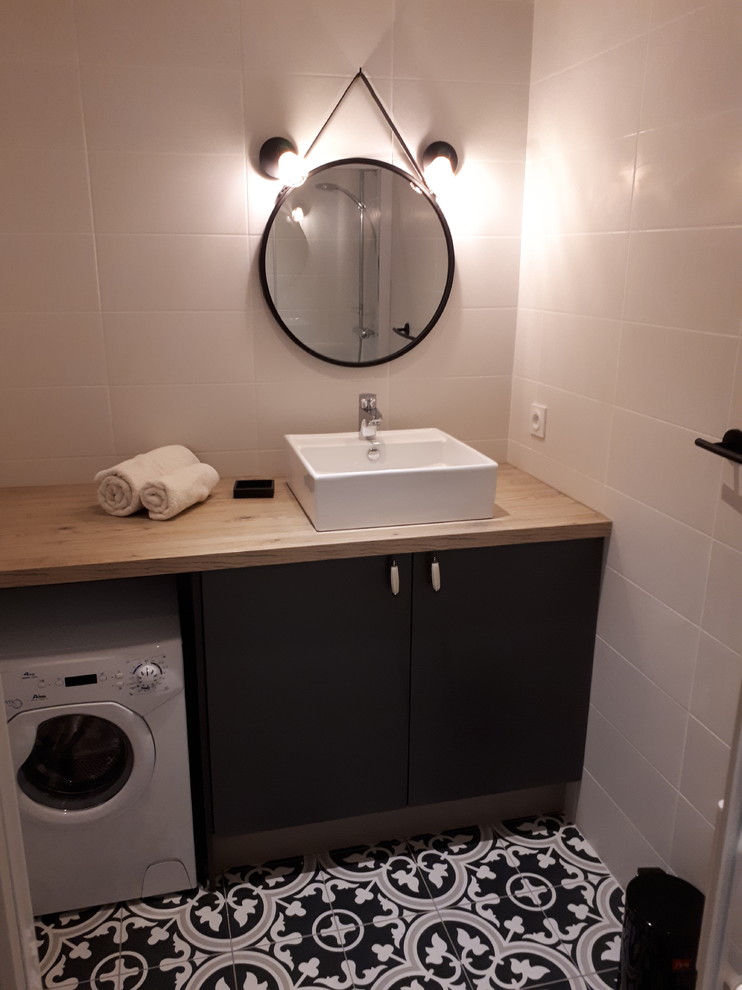 Modelo de cuarto de baño principal escandinavo de tamaño medio con ducha a ras de suelo, baldosas y/o azulejos beige, suelo de azulejos de cemento y suelo negro