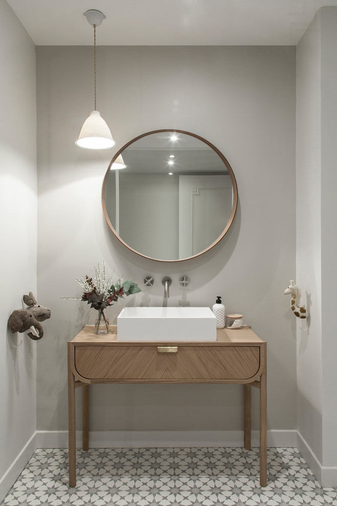 Immagine di una stanza da bagno nordica con ante lisce, ante in legno scuro, pareti grigie, lavabo a bacinella, top in legno, pavimento grigio e top marrone