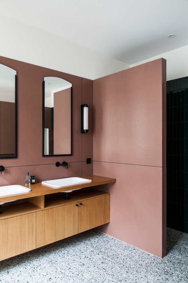 Cette image montre une salle de bain design en bois brun avec un placard à porte plane, un mur blanc, un lavabo posé, un plan de toilette en bois, un sol gris et un plan de toilette marron.