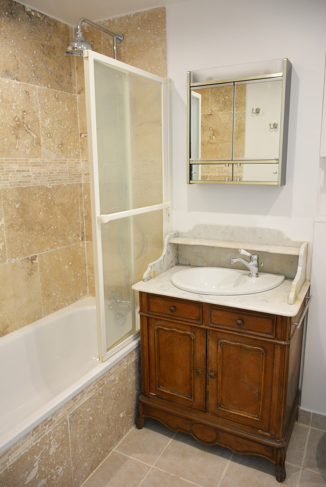 Exemple d'une salle de bain principale nature avec un placard à porte plane, WC suspendus, un carrelage beige, un carrelage de pierre, un mur blanc, tomettes au sol, un lavabo encastré, un plan de toilette en marbre, un sol beige et un plan de toilette blanc.