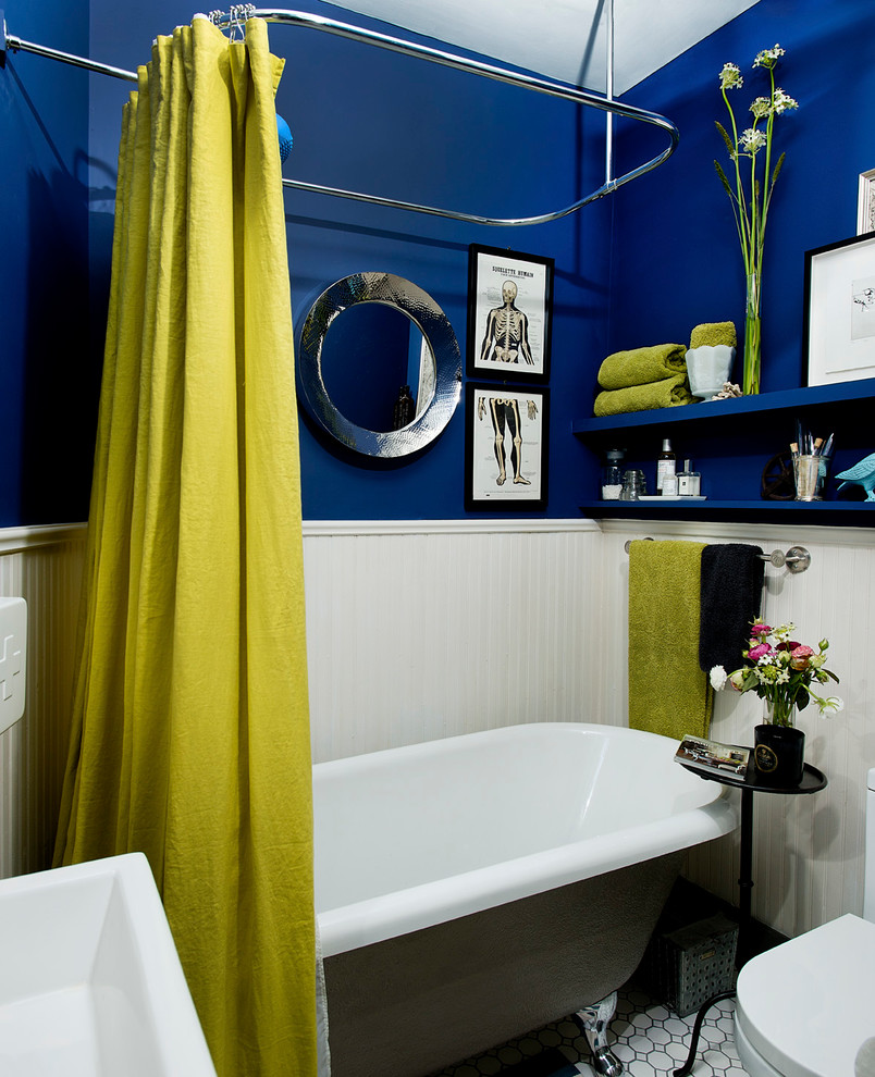 Imagen de cuarto de baño contemporáneo pequeño con armarios abiertos, bañera con patas y paredes azules