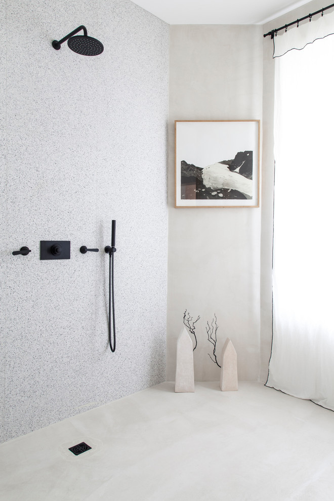 Réalisation d'une salle de bain design avec un carrelage blanc et un sol gris.