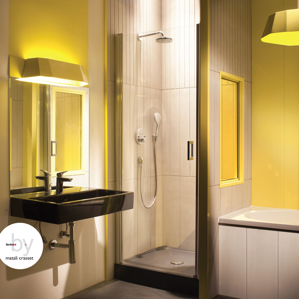 Imagen de cuarto de baño principal actual de tamaño medio con sanitario de pared, ducha empotrada, paredes amarillas y lavabo suspendido