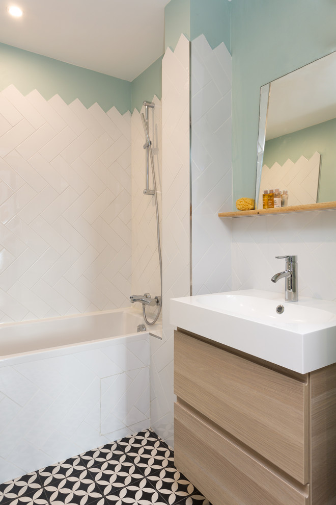 Small contemporary family bathroom in Paris with a submerged bath, white tiles, metro tiles, green walls, cement flooring, a console sink and black floors.