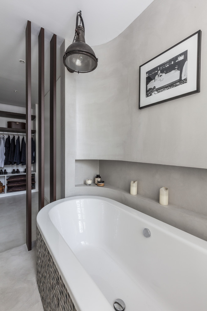 Foto di una stanza da bagno padronale contemporanea di medie dimensioni con vasca freestanding, pareti grigie e pavimento in cemento
