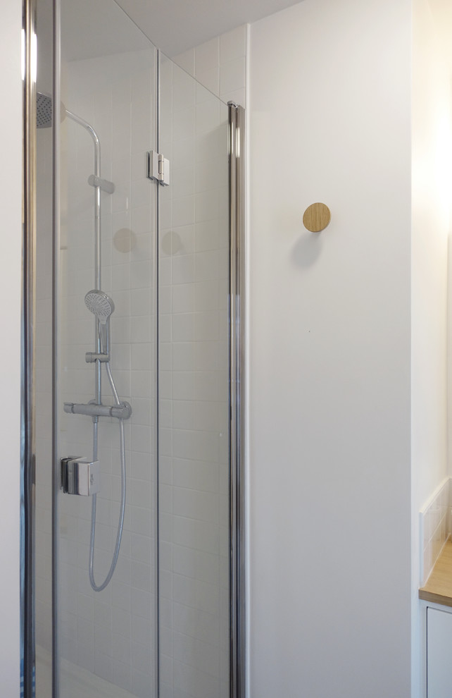 Inspiration for a small contemporary shower room bathroom in Le Havre with beaded cabinets, white cabinets, an alcove shower, a one-piece toilet, white tiles, ceramic tiles, ceramic flooring, a built-in sink, wooden worktops, blue floors and a hinged door.