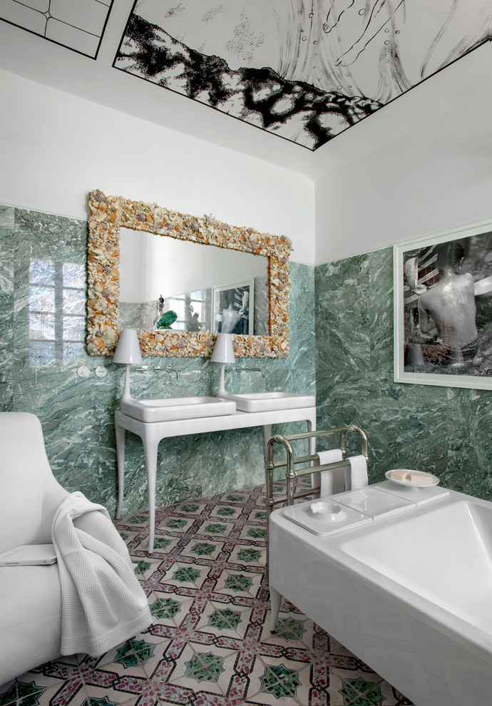 Immagine di una stanza da bagno mediterranea con vasca freestanding, piastrelle verdi, lastra di pietra, pareti bianche e lavabo a consolle