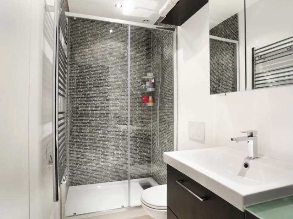 Foto de cuarto de baño principal moderno pequeño con ducha empotrada, sanitario de pared, baldosas y/o azulejos de piedra caliza, paredes blancas, lavabo tipo consola, suelo beige y ducha con puerta corredera