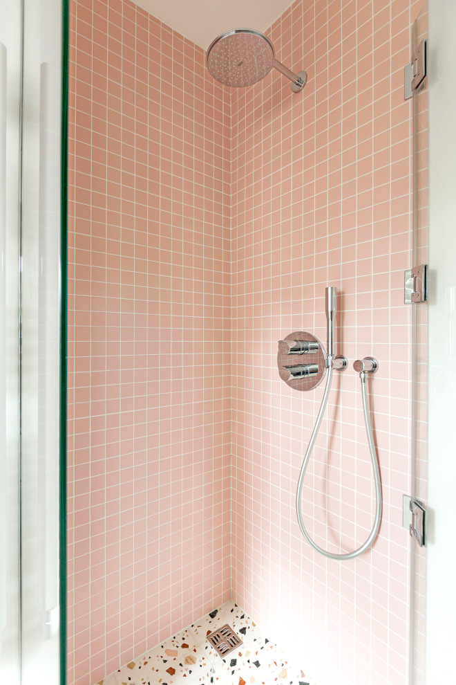 Inspiration för små shabby chic-inspirerade rosa badrum med dusch, med luckor med profilerade fronter, vita skåp, en hörndusch, en vägghängd toalettstol, rosa kakel, keramikplattor, vita väggar, terrazzogolv, ett konsol handfat, bänkskiva i terrazo, flerfärgat golv och dusch med gångjärnsdörr