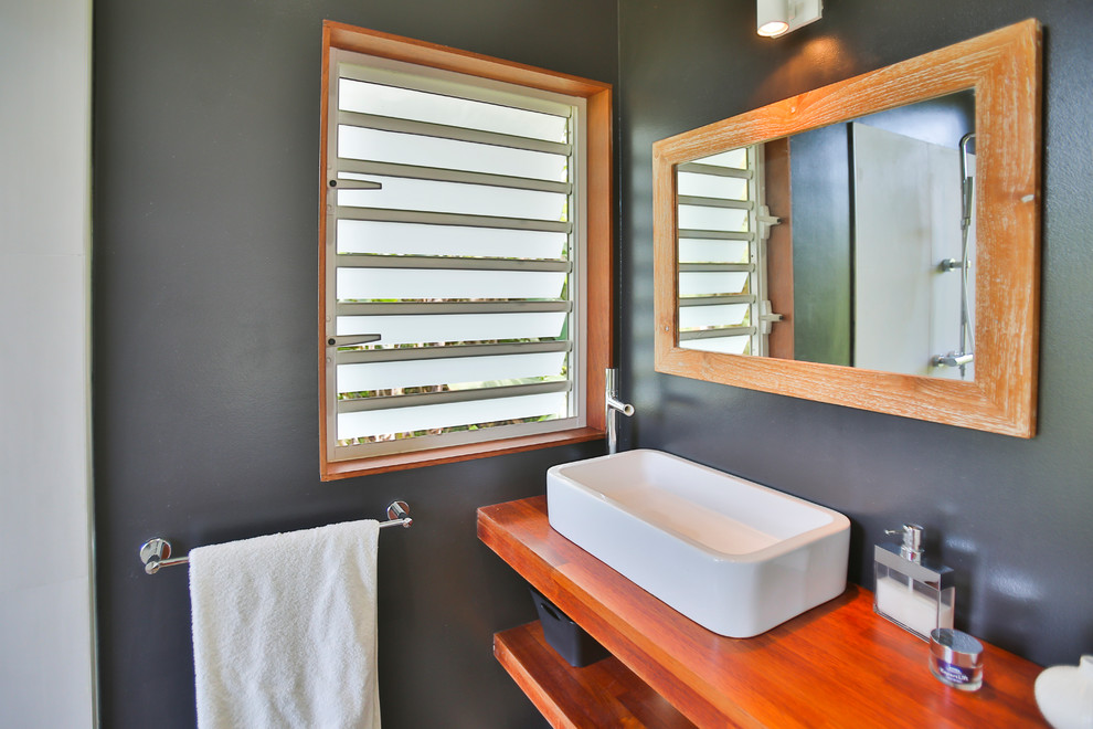 Пример оригинального дизайна: маленькая ванная комната в стиле модернизм с открытым душем, черными стенами, душевой кабиной, накладной раковиной, столешницей из дерева, серым полом, открытым душем и открытыми фасадами для на участке и в саду