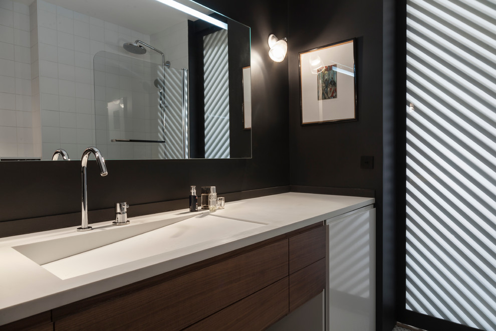 Inspiration pour une salle de bain principale design de taille moyenne avec un placard à porte affleurante, des portes de placard marrons, un carrelage noir, un mur noir, un sol en carrelage de porcelaine, un plan vasque, un sol blanc et un plan de toilette blanc.