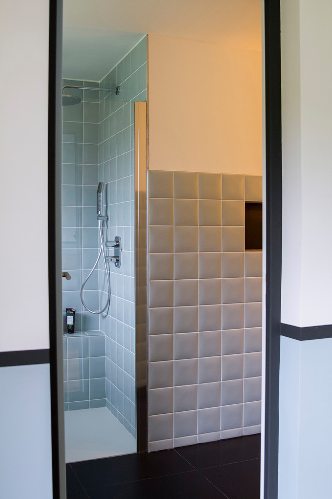 Idée de décoration pour une petite salle d'eau design avec une douche ouverte, un carrelage bleu, des carreaux de céramique, un mur blanc, un sol en carrelage de céramique, un lavabo posé, un plan de toilette en bois et un sol noir.