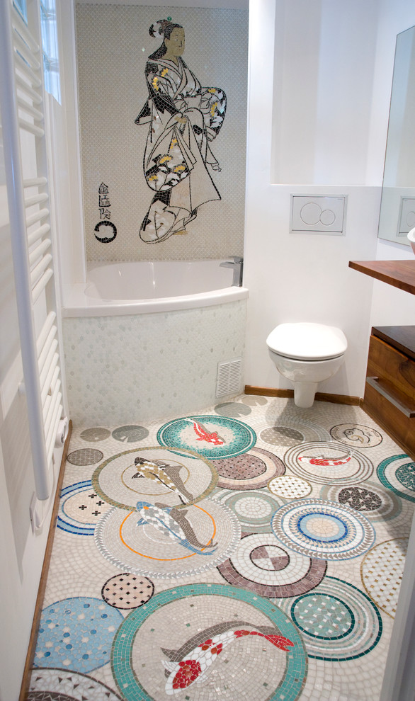 Inspiration for a small world-inspired ensuite bathroom in Paris with flat-panel cabinets, medium wood cabinets, wooden worktops, a shower/bath combination, multi-coloured tiles, porcelain tiles, white walls, mosaic tile flooring, a wall mounted toilet, a vessel sink and a corner bath.