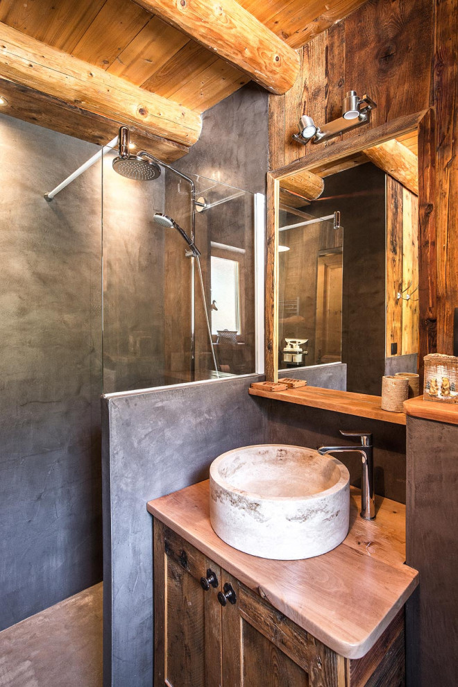 Idéer för att renovera ett litet rustikt brun brunt badrum med dusch, med skåp i shakerstil, skåp i mellenmörkt trä, en dusch i en alkov, grå kakel, bruna väggar, ett fristående handfat, träbänkskiva och med dusch som är öppen