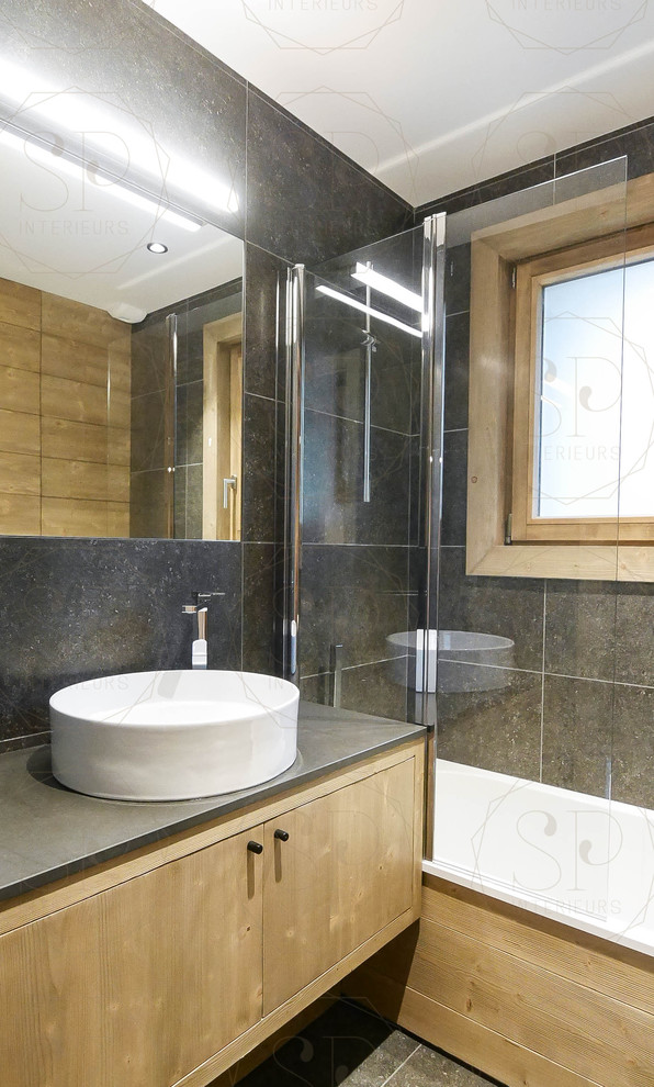 Foto de cuarto de baño rural con bañera esquinera, baldosas y/o azulejos de mármol, paredes negras, suelo de mármol, lavabo encastrado y suelo negro