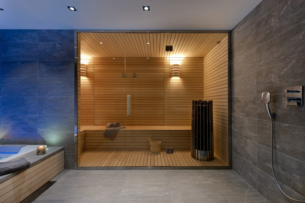 Cette photo montre un sauna tendance avec une baignoire posée, une douche ouverte, un mur gris, un sol gris et aucune cabine.