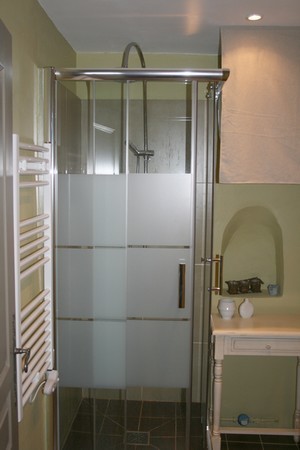 Inspiration för små medelhavsstil badrum med dusch, med en hörndusch, en vägghängd toalettstol, grön kakel, cementkakel, gröna väggar, cementgolv, ett konsol handfat, brunt golv och dusch med skjutdörr