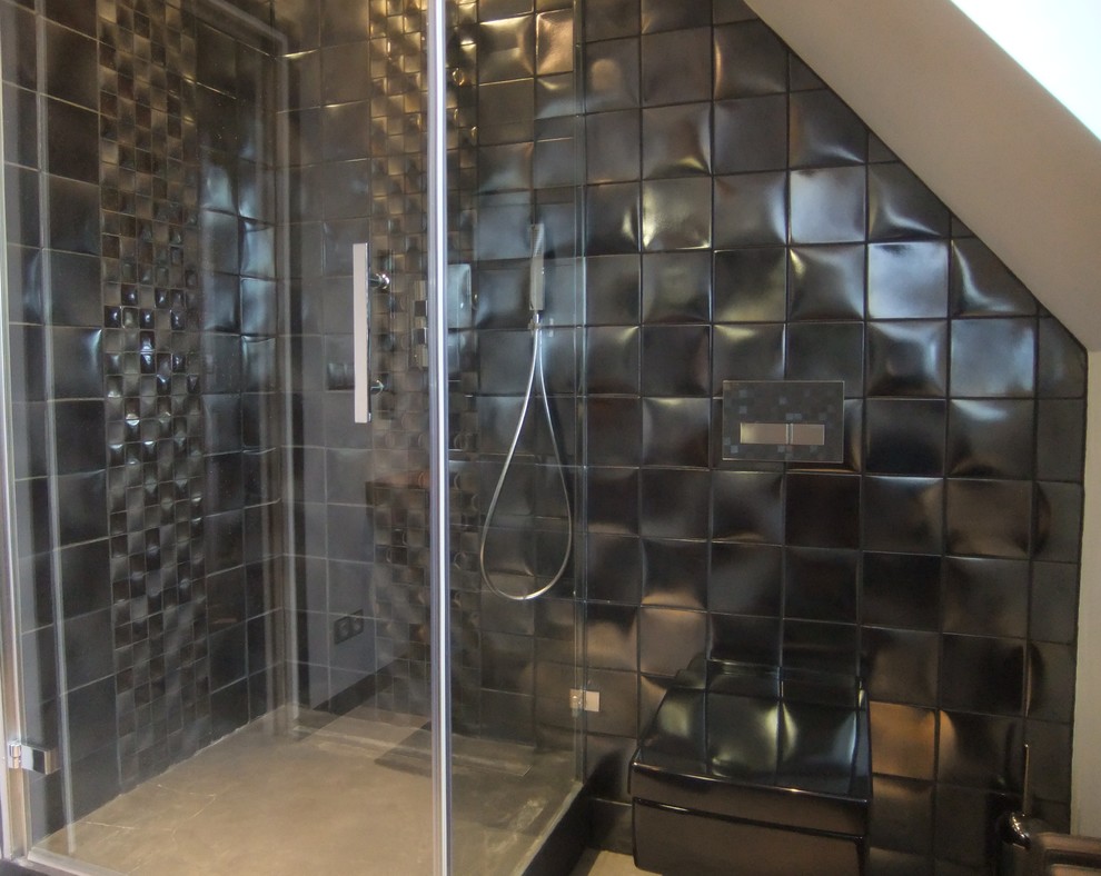 Modern inredning av ett mellanstort badrum med dusch, med betonggolv, grått golv, en hörndusch, en vägghängd toalettstol, svart kakel, keramikplattor, svarta väggar, ett nedsänkt handfat, träbänkskiva och dusch med gångjärnsdörr