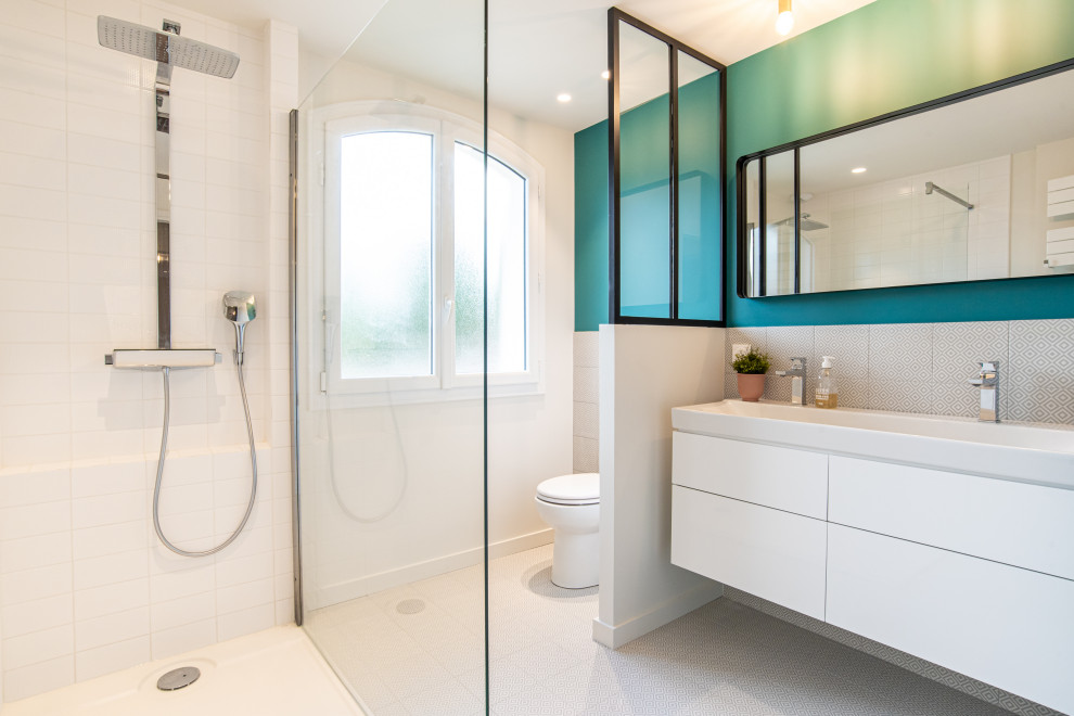 トゥールーズにあるコンテンポラリースタイルのおしゃれな浴室 (フラットパネル扉のキャビネット、白いキャビネット、コーナー設置型シャワー、グレーのタイル、緑の壁、横長型シンク、グレーの床) の写真