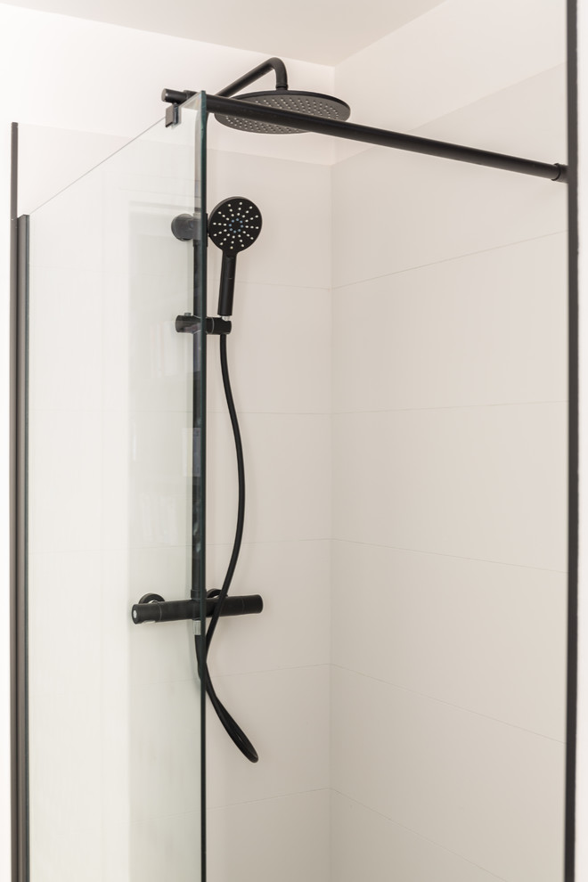Idéer för att renovera ett mellanstort funkis svart svart en-suite badrum, med vita skåp, en kantlös dusch, vita väggar, klinkergolv i terrakotta, ett nedsänkt handfat, svart golv, dusch med gångjärnsdörr, släta luckor, vit kakel, porslinskakel och bänkskiva i akrylsten