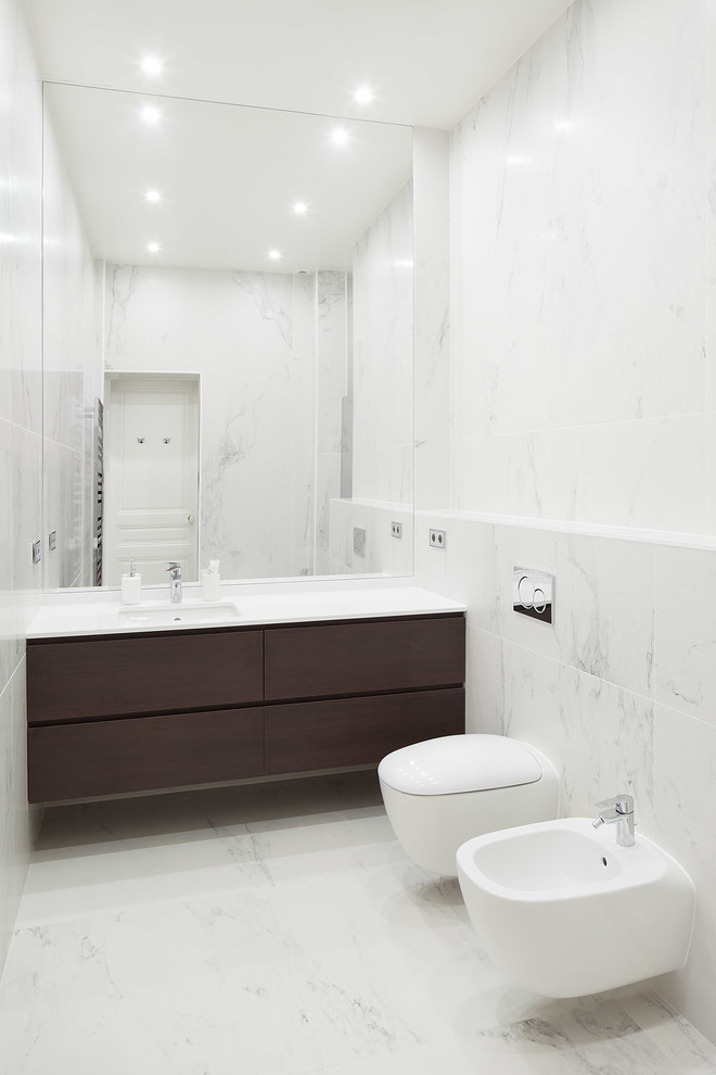 Inspiration pour une grande salle de bain principale design en bois foncé avec WC suspendus, un carrelage blanc, des carreaux de céramique, un mur blanc, un sol en carrelage de céramique, un lavabo encastré et un plan de toilette en quartz.