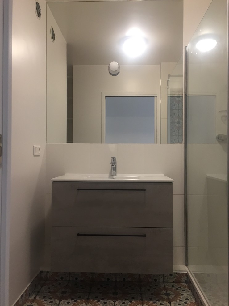 Cette photo montre une douche en alcôve principale moderne de taille moyenne avec un carrelage blanc, un mur blanc, un lavabo intégré, un sol multicolore, aucune cabine et un plan de toilette blanc.