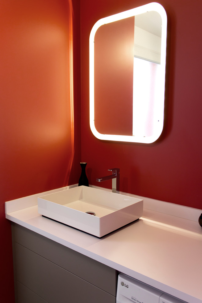 Inredning av ett modernt mellanstort en-suite badrum, med släta luckor, bruna skåp, brun kakel, bänkskiva i akrylsten, en kantlös dusch, en vägghängd toalettstol, keramikplattor, röda väggar, klinkergolv i keramik och ett fristående handfat