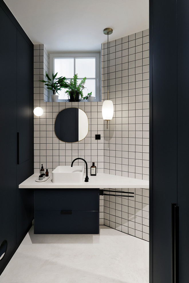 パリにあるおしゃれな浴室 (フラットパネル扉のキャビネット、黒いキャビネット、白いタイル、白い壁、ベッセル式洗面器、白い床、白い洗面カウンター) の写真