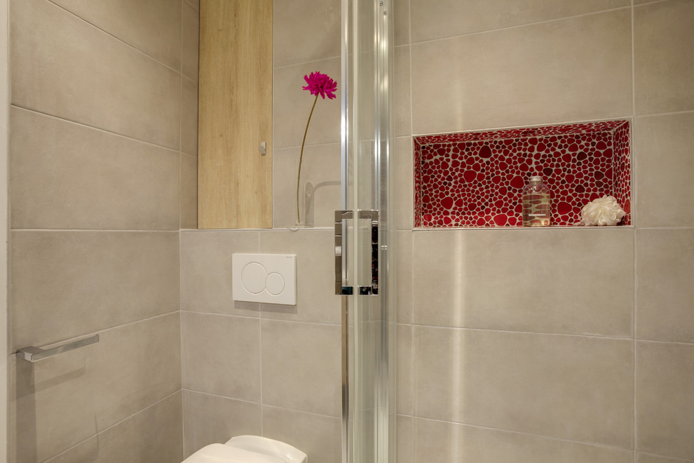 Cette photo montre une petite salle de bain principale tendance avec une douche d'angle, WC suspendus, un carrelage gris, des carreaux de céramique, un mur gris, un sol en carrelage de céramique, un sol gris et une cabine de douche à porte coulissante.