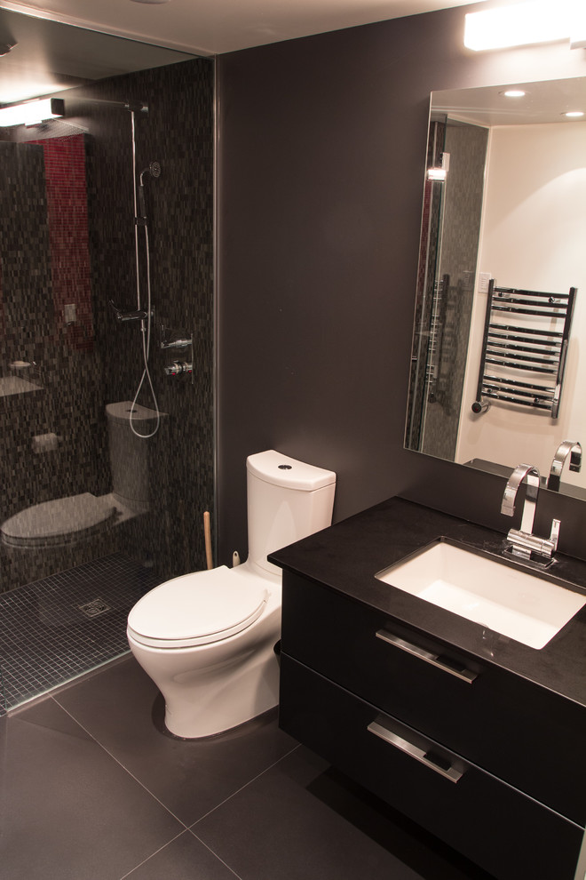 Inredning av ett modernt badrum med dusch, med släta luckor, svarta skåp, en dubbeldusch, en toalettstol med separat cisternkåpa, grå kakel, mosaik, vita väggar, klinkergolv i porslin, ett undermonterad handfat, granitbänkskiva, grått golv och dusch med gångjärnsdörr