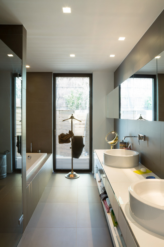 Ispirazione per una stanza da bagno padronale minimal di medie dimensioni con vasca sottopiano, pareti marroni e pavimento grigio