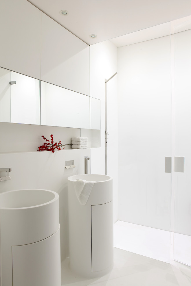 Свежая идея для дизайна: ванная комната в современном стиле с плоскими фасадами, белыми фасадами, душем без бортиков, белой плиткой, белыми стенами, раковиной с пьедесталом, бежевым полом и душем с распашными дверями - отличное фото интерьера