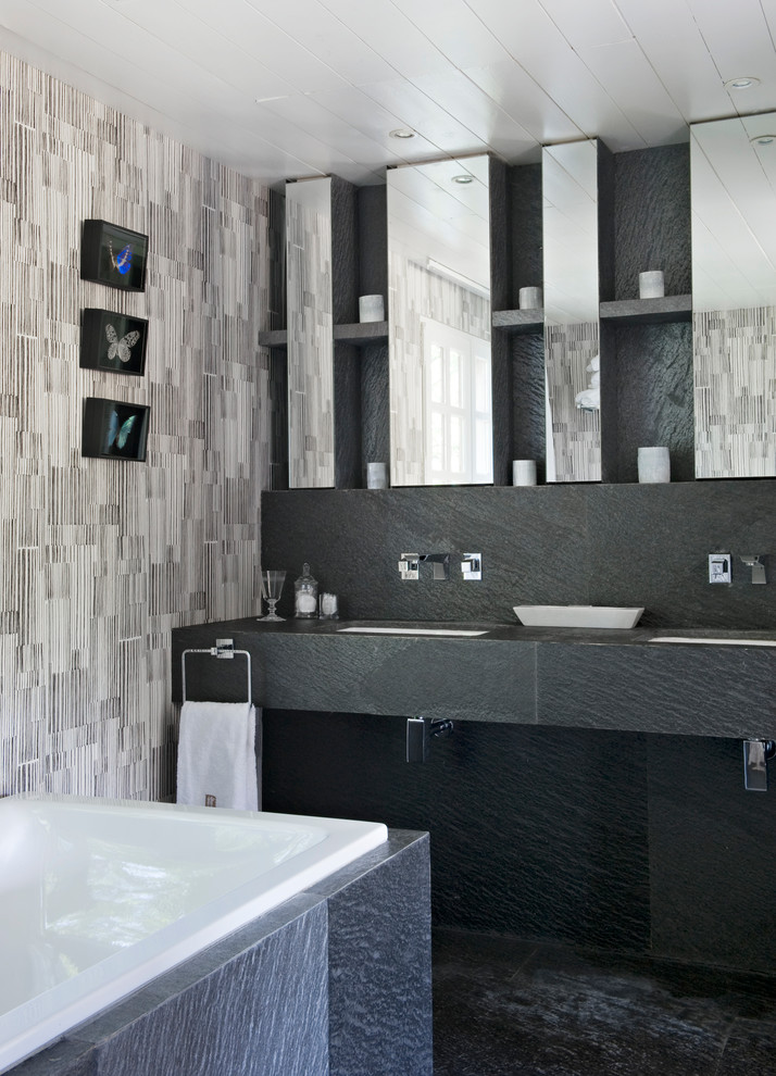 Medium sized contemporary grey and white ensuite bathroom in Other with grey tiles, a submerged bath, grey walls and a submerged sink.