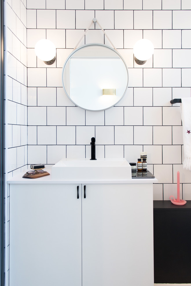 This is an example of a small contemporary bathroom in Paris with a built-in sink, white tiles, white walls and white cabinets.