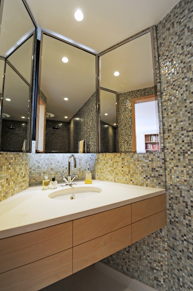 Diseño de cuarto de baño contemporáneo de tamaño medio con puertas de armario de madera oscura, ducha empotrada, baldosas y/o azulejos beige, baldosas y/o azulejos blancos, baldosas y/o azulejos azules, baldosas y/o azulejos grises, baldosas y/o azulejos en mosaico, aseo y ducha y lavabo bajoencimera