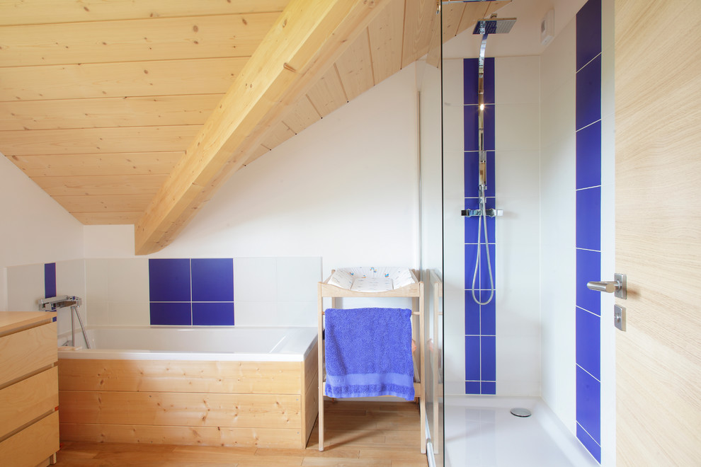 Cette image montre une salle de bain principale rustique en bois clair de taille moyenne avec une douche ouverte, un carrelage blanc, un carrelage bleu, un mur blanc, parquet clair, une baignoire posée, aucune cabine et du carrelage bicolore.