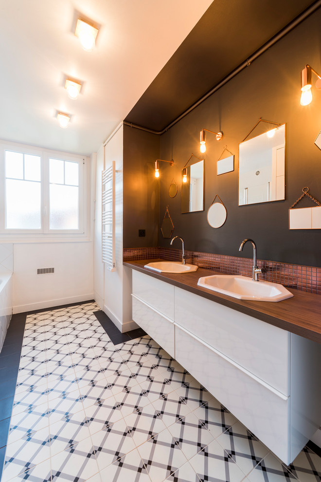 Inspiration for a contemporary brown tile mosaic tile floor and white floor bathroom remodel in Paris with flat-panel cabinets, white cabinets, black walls, a drop-in sink, wood countertops and brown countertops
