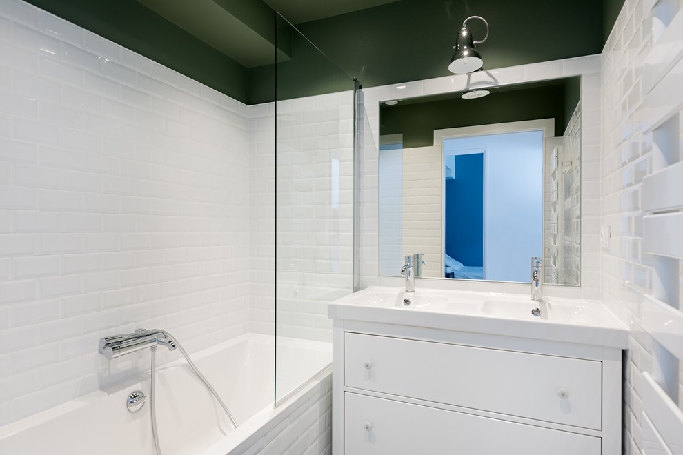 На фото: ванная комната среднего размера в современном стиле с фасадами с декоративным кантом, белыми фасадами, полновстраиваемой ванной, белой плиткой, стеклянной плиткой, белыми стенами, полом из керамической плитки, душевой кабиной, накладной раковиной, белым полом и открытым душем