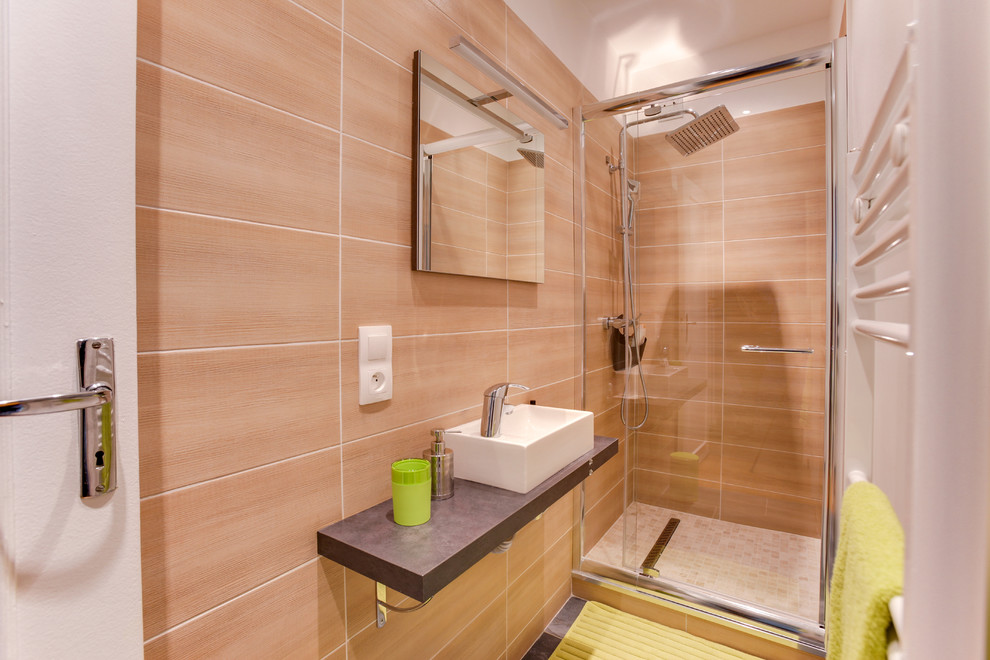 Réalisation d'une salle de bain principale design avec une douche à l'italienne, un carrelage beige, un mur beige, un sol en carrelage de céramique, une grande vasque, un sol beige, une cabine de douche à porte battante et un plan de toilette marron.