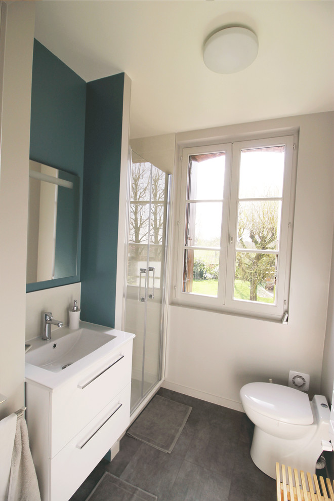 Пример оригинального дизайна: маленькая ванная комната в стиле модернизм с душем в нише, унитазом-моноблоком, цементной плиткой, синими стенами, полом из ламината, душевой кабиной и серым полом для на участке и в саду