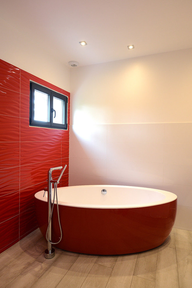 Cette image montre une grande salle de bain principale design avec une baignoire posée, un carrelage rouge, des carreaux de céramique, un mur blanc et un sol en carrelage de céramique.