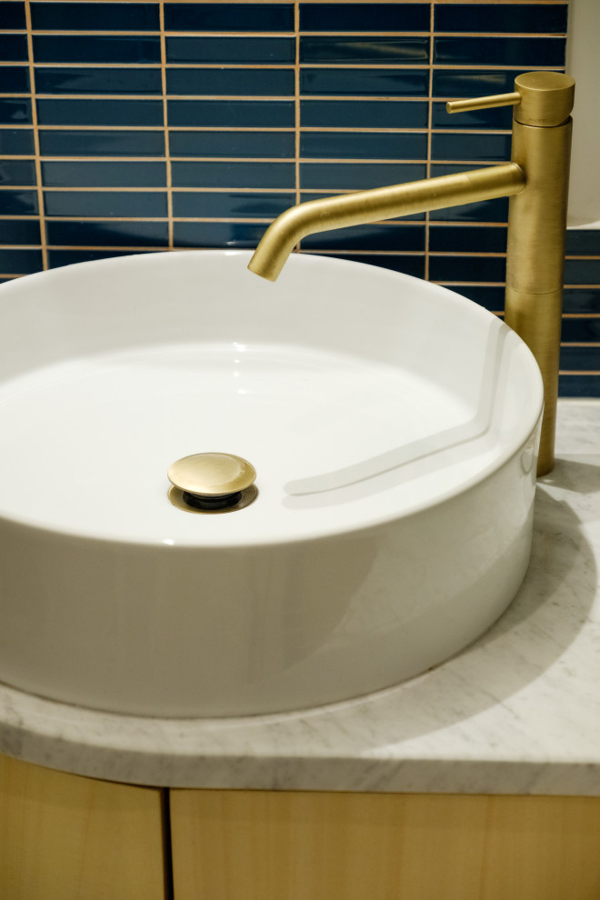 Réalisation d'une petite salle de bain design en bois clair avec un carrelage bleu, des carreaux de céramique, un mur blanc, un sol en marbre, une vasque, un plan de toilette en marbre, un sol blanc, une cabine de douche à porte battante, un plan de toilette blanc, une niche, meuble simple vasque et meuble-lavabo encastré.