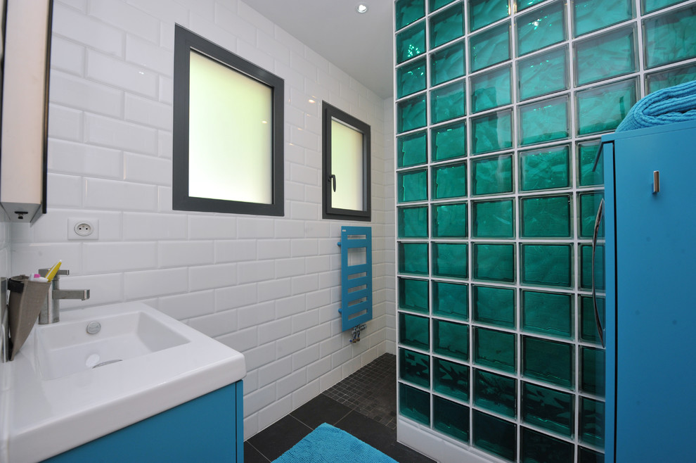 Réalisation d'une petite salle de bain design pour enfant avec des portes de placard bleues, une douche à l'italienne, un carrelage noir, des carreaux de céramique, un mur blanc, un sol en carrelage de céramique, un plan de toilette en surface solide, un placard avec porte à panneau encastré et un lavabo encastré.
