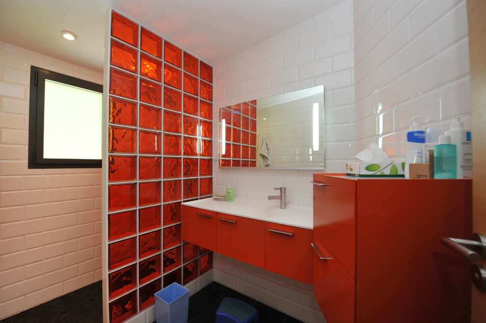 Modelo de cuarto de baño infantil contemporáneo con armarios con rebordes decorativos, puertas de armario naranjas, jacuzzi, ducha a ras de suelo, baldosas y/o azulejos negros, baldosas y/o azulejos de cerámica, paredes blancas, suelo de baldosas de cerámica, lavabo bajoencimera y encimera de acrílico