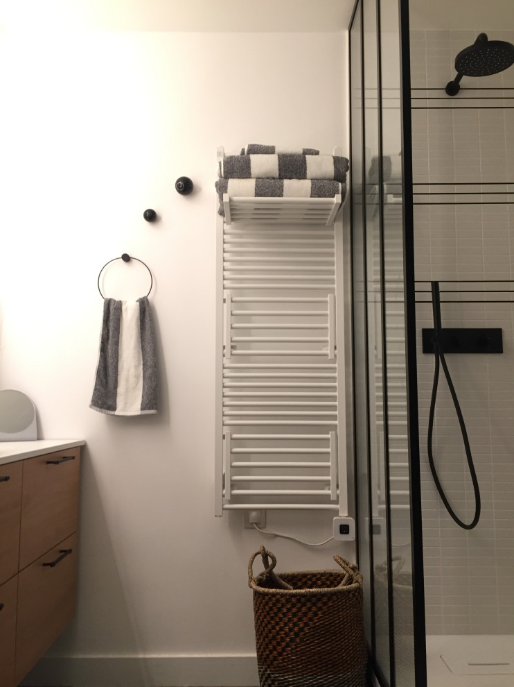 Kleines Modernes Duschbad mit hellen Holzschränken, offener Dusche, Wandtoilette mit Spülkasten, weißen Fliesen, weißer Wandfarbe, Keramikboden, Einbauwaschbecken, Laminat-Waschtisch, grünem Boden, offener Dusche und weißer Waschtischplatte in Paris