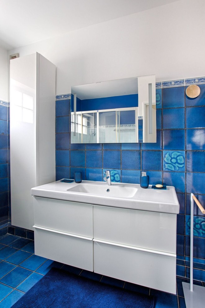 Réalisation d'une salle de bain principale design de taille moyenne avec un carrelage bleu, un mur blanc, un lavabo intégré et un sol bleu.