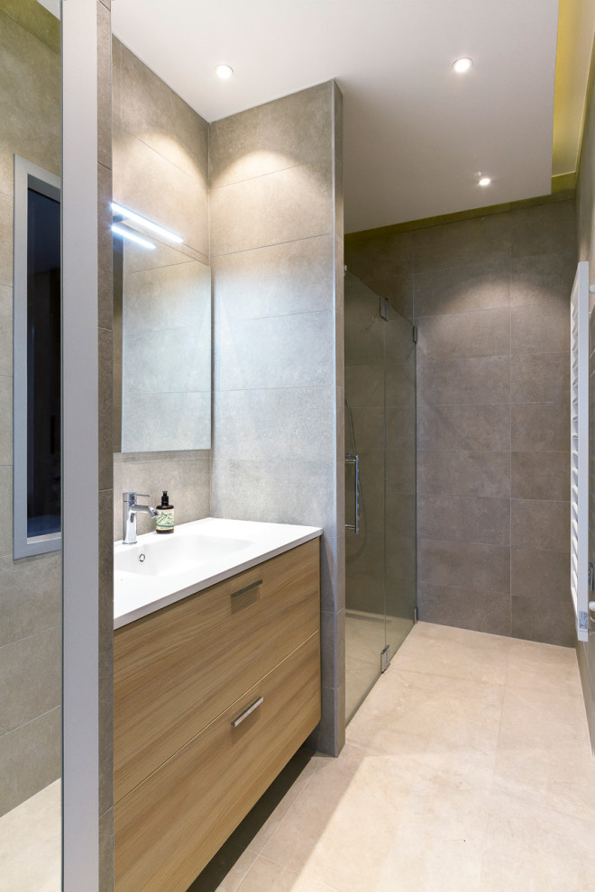 Mid-sized trendy master gray tile and ceramic tile ceramic tile, beige floor, single-sink and tray ceiling walk-in shower photo in Paris with beaded inset cabinets, light wood cabinets, gray walls, a console sink, a hinged shower door, white countertops and a freestanding vanity